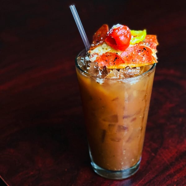A Firehouse Pizza Bloody Mary cocktail, garnished with pepperoni, cherry tomatoes, and a pepper.