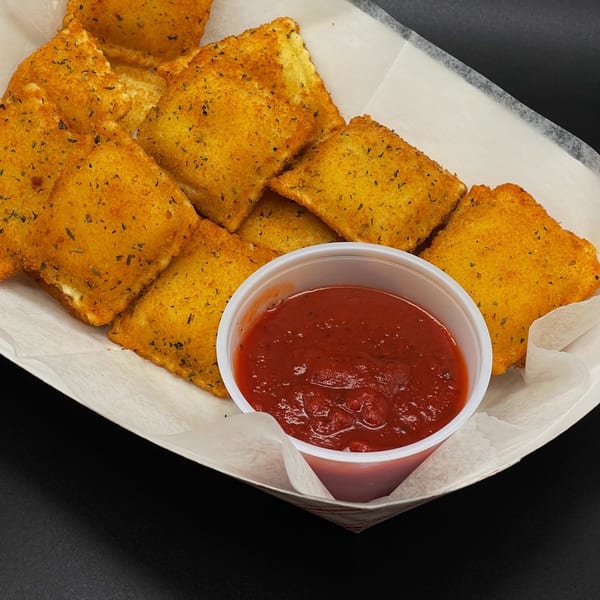 Golden-brown toasted ravioli with herbs, served in a paper tray with a side of marinara sauce.