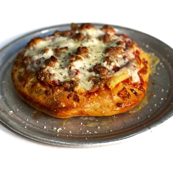 Firehouse Pizza's small, round sausage pizza with melted cheese and herbs on a metal pan.